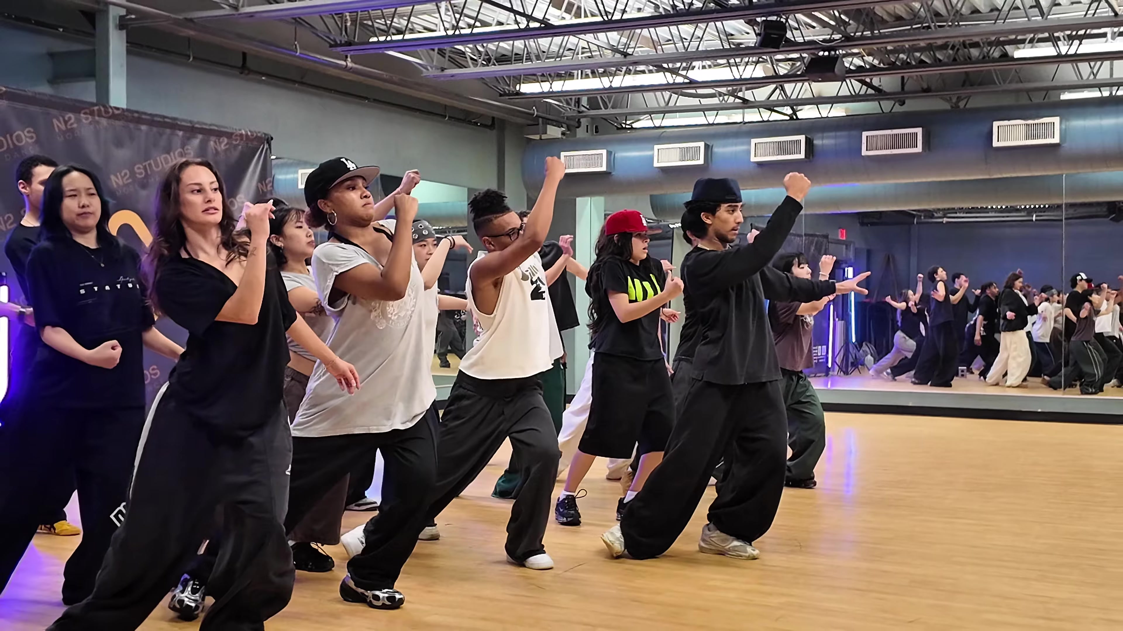 A group of dancers learning choreography together in a studio
