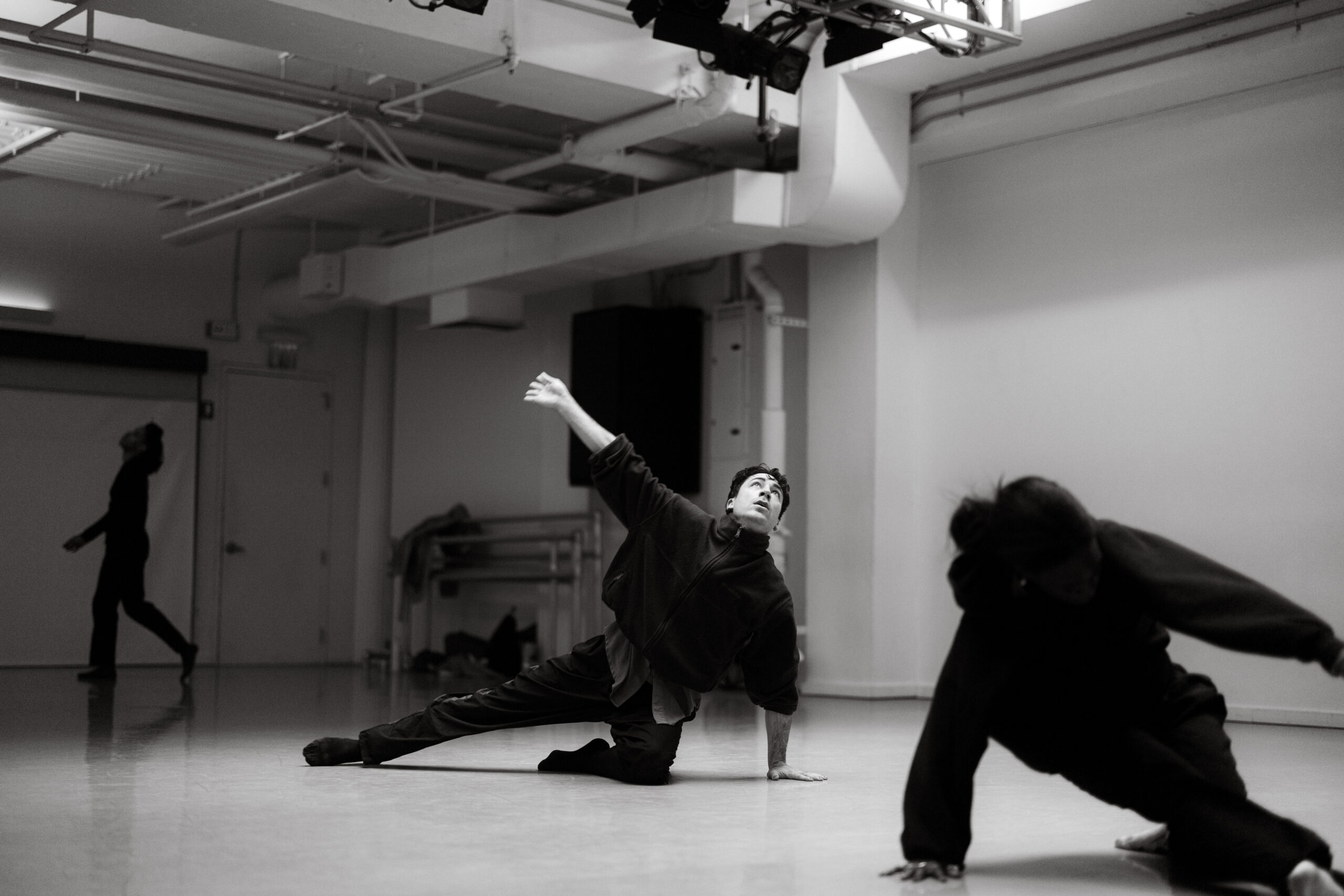 Dancers practicing expressive choreography in a bright modern dance studio