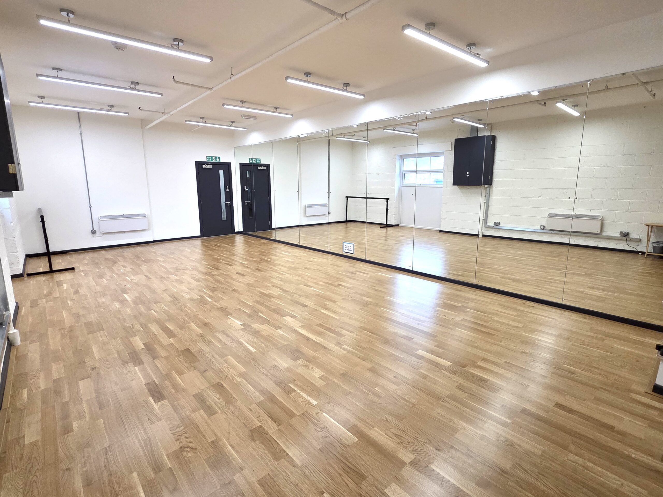 Dancers practicing coordinated movement in a bright studio